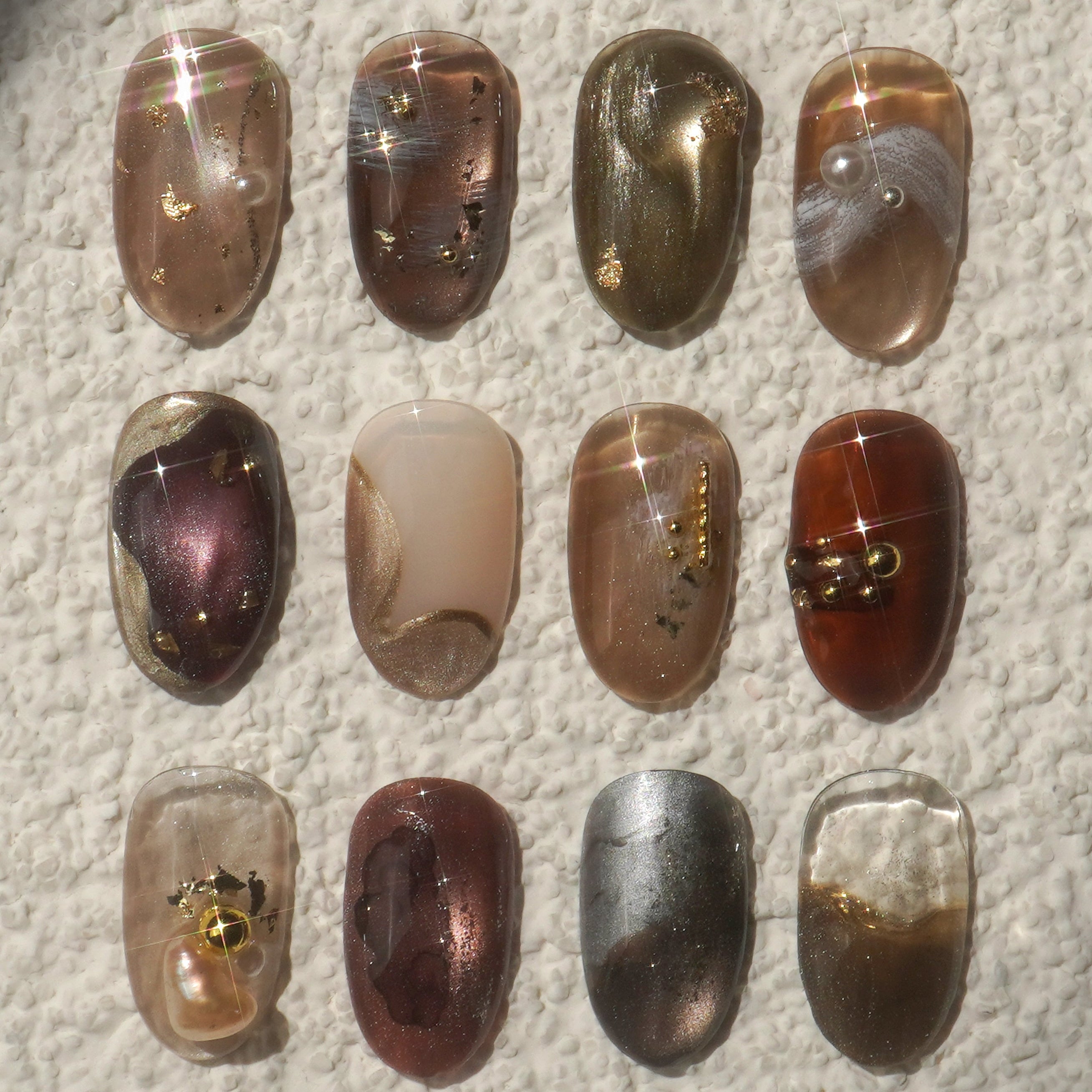 Collection of nail art designs on a textured surface with 'espresso' branding.