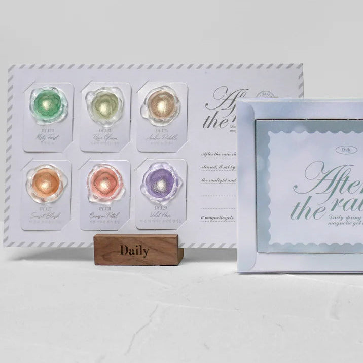 Set of colorful gel nail polishes with a wooden stand and a decorative card on a white background.